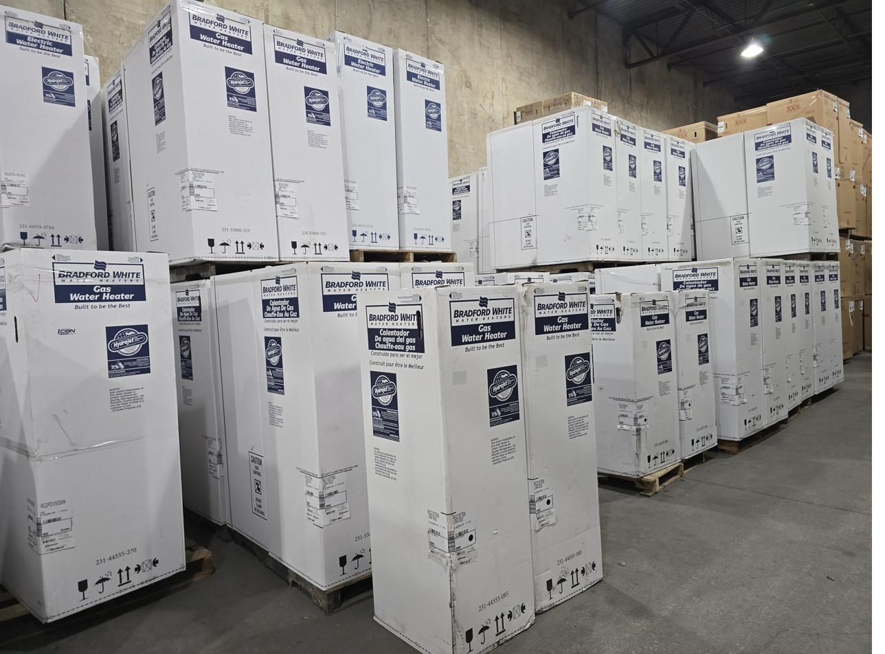 Bradford White gas and electric water heaters stacked in our warehouse